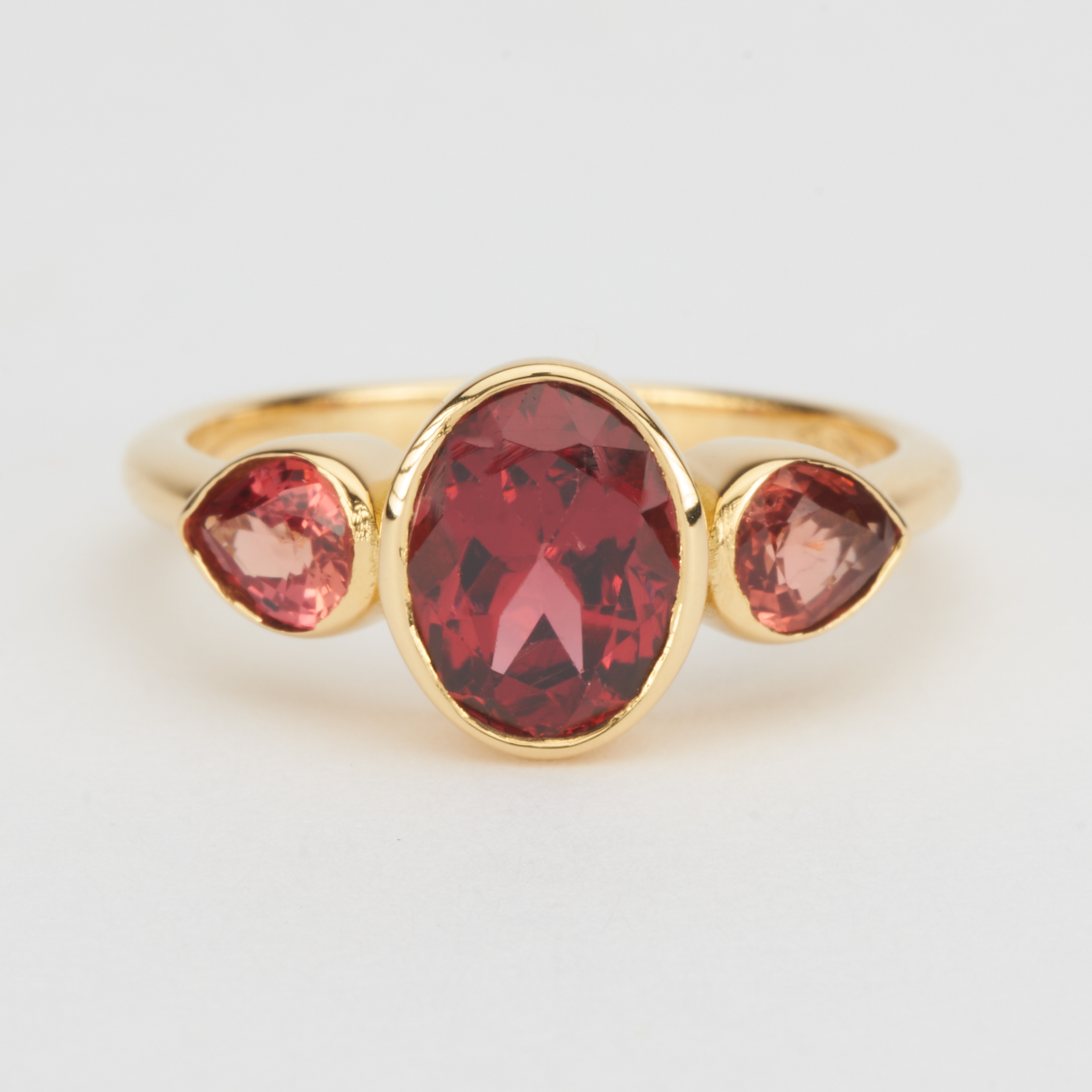 Ring : Oval shaped garnet between two beautiful juicy orange pear shaped sapphires in 18K yellow gold.